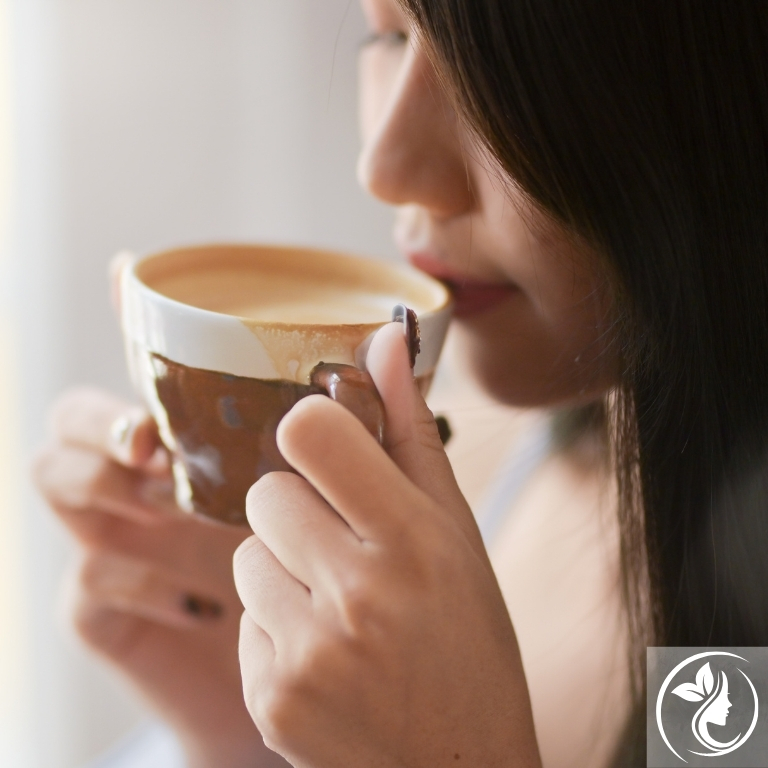 コーヒーを飲む女性。カフェインのむくみ解消や代謝アップ効果を活かし、小顔や若見えをサポートする美容習慣｜足立区梅島AloHaの35〜50代向けケア