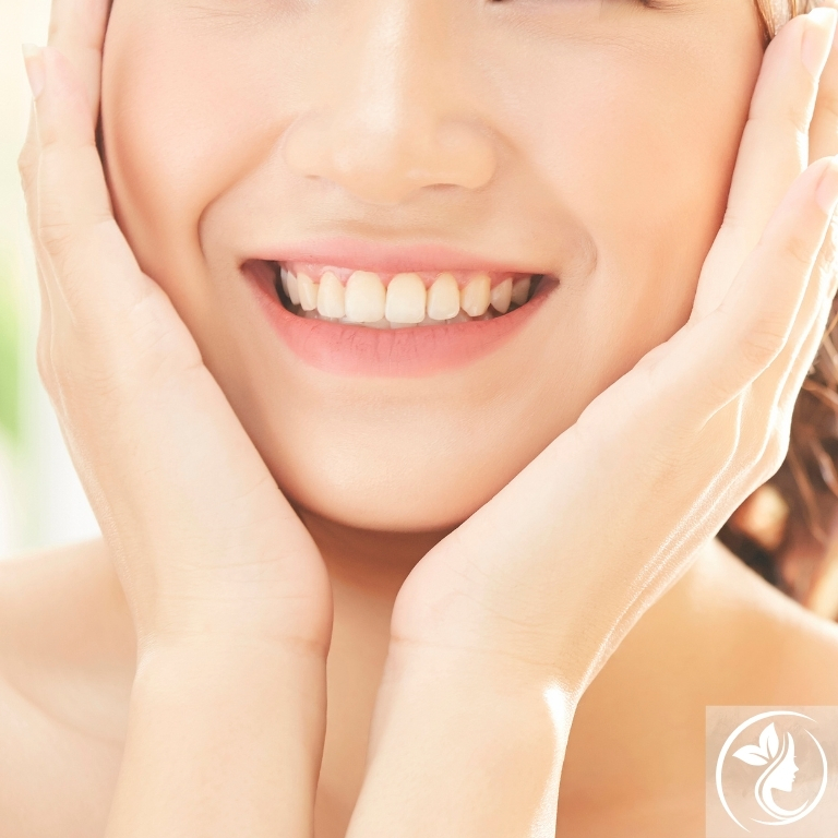 笑顔でフェイスラインに手を添える女性。40代からの若見えを叶える姿勢改善と小顔矯正。姿勢美矯正で黄金比フェイスラインを導く足立区梅島AloHaの美容整体