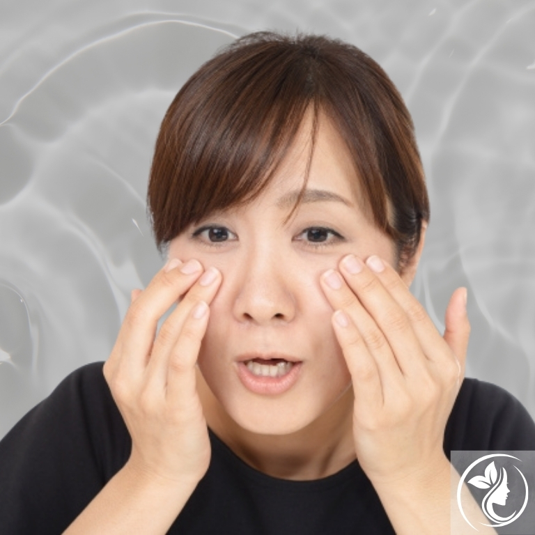 目の下のクマを気にして頬に手を当てる女性。血流や筋肉・骨格のアンバランスが原因の“寝ても消えないクマ”を根本改善する足立区梅島AloHaの小顔矯正